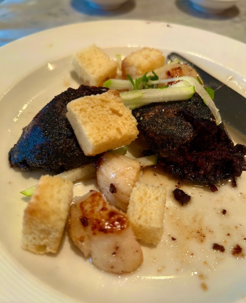 Sautéed scallops, black pudding, apple, cabernet sauvignon dressing as a starter dish from Côte Brasserie, London 